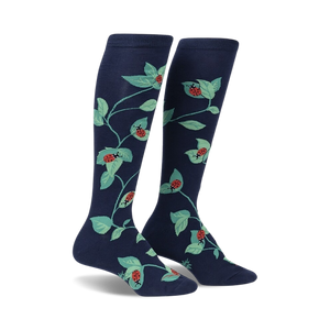 Pair of navy blue knee-high socks with a repeating pattern of ladybugs and green leaves.