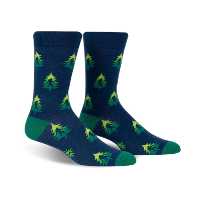 Pair of crew socks in navy blue with repeating lime green and darker green Christmas tree pattern. Green cuffs.