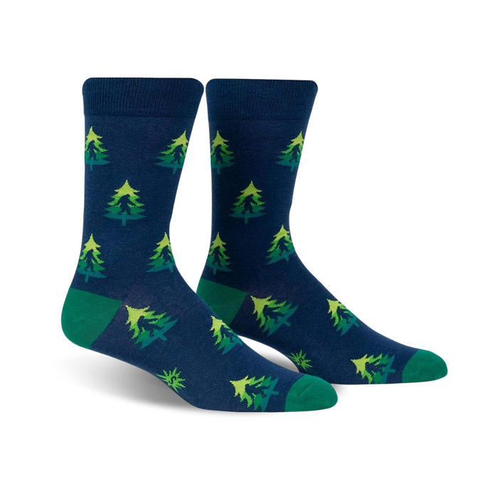 Pair of crew socks in navy blue with repeating lime green and darker green Christmas tree pattern. Green cuffs. }}