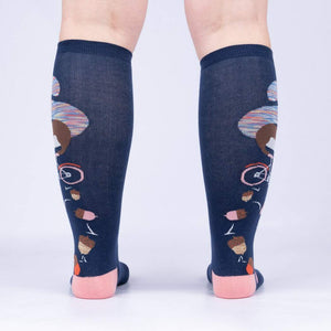 Rear view of the 'Feeling Squirrelly' knee-high socks on a person's legs, highlighting the full design on both socks.
