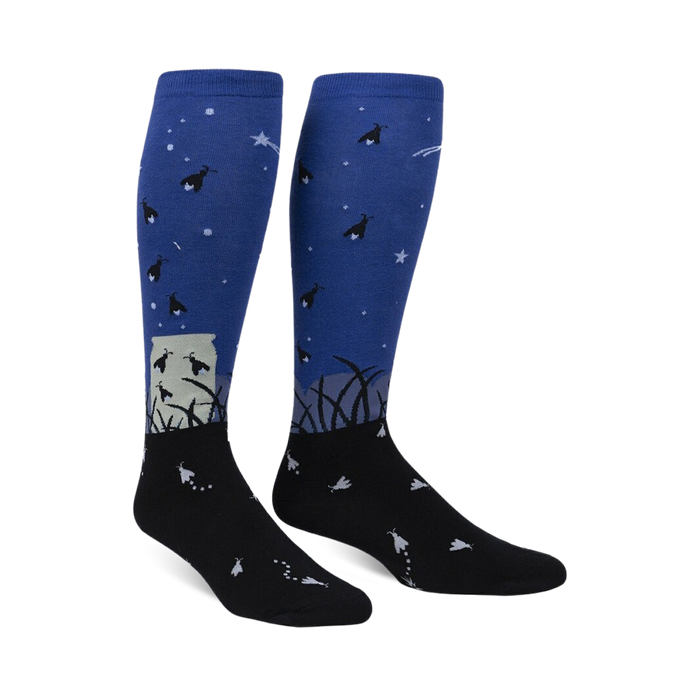 Pair of blue and black knee-high socks with a firefly and night sky design.  They glow in the dark!