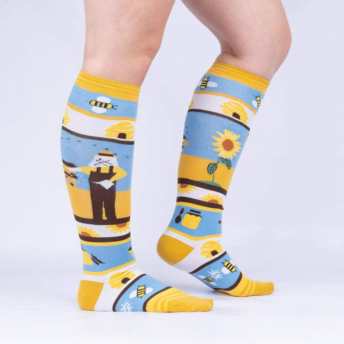 Lifestyle shot: A model's legs wearing the 'Honey, You're a Keeper' knee-high socks.