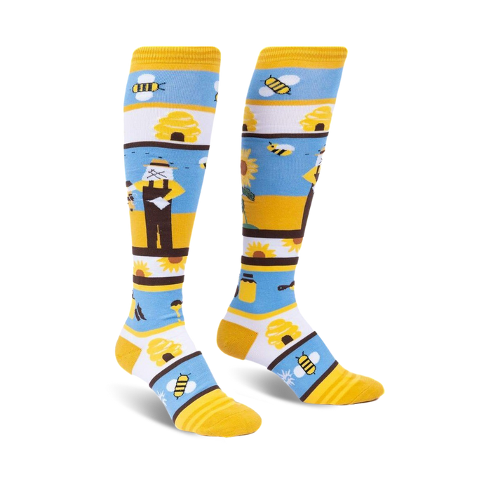 Pair of women's knee-high socks. Yellow, white, and blue stripes with bee, sunflower, and honey pot designs.