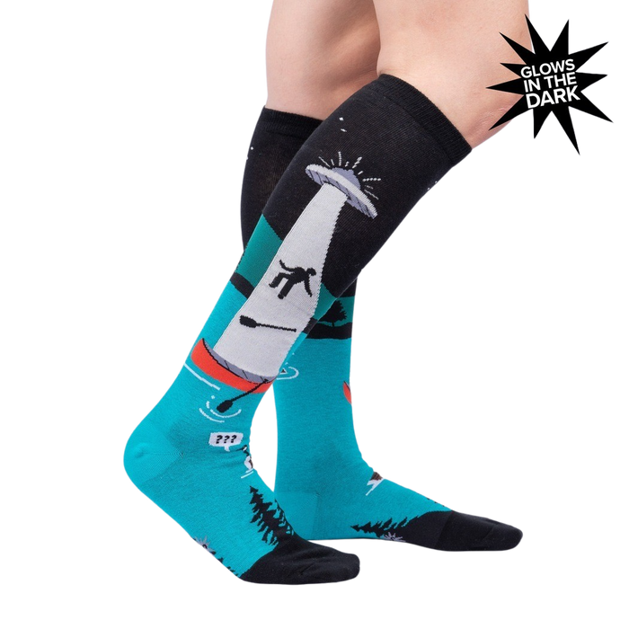 Lifestyle photo showcasing the 'Out of Boaty Experience' glow-in-the-dark socks on a model's legs.