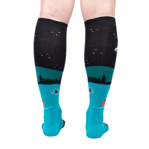 Rear view of the socks highlighting the full design. The socks are teal and black and glow in the dark.