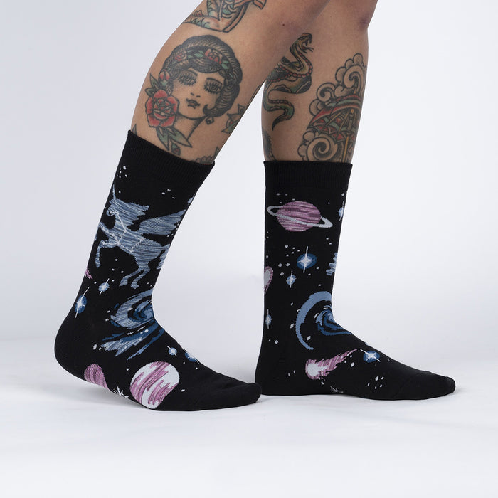 A pair of black socks with a colorful pattern of planets, stars, and a pegasus.