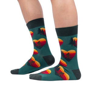 Lifestyle shot showing the socks on a person's legs; teal socks with Sasquatch and sunset heart design.