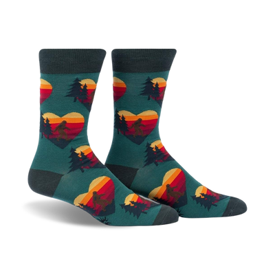 Crew socks in teal with a repeating pattern of retro sunset hearts featuring Sasquatch silhouettes and pine trees.