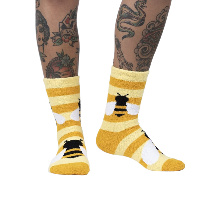 Lifestyle photo showing the Bee Cozy Slipper Socks on a person's legs.