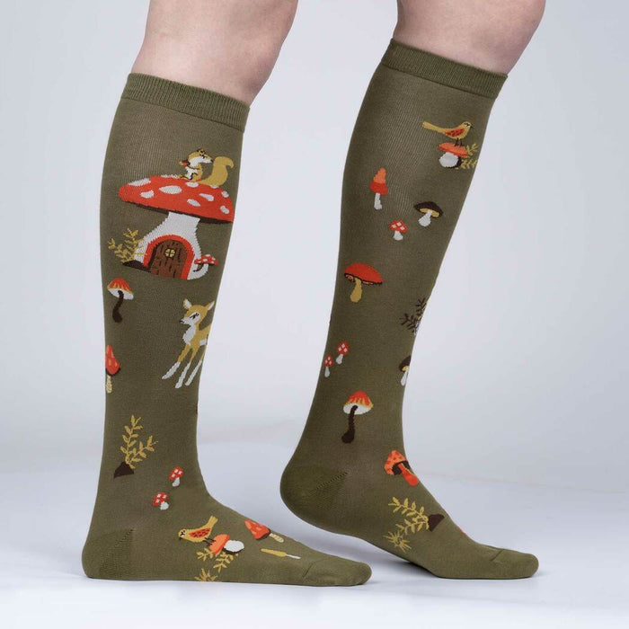 A pair of green knee-high socks with a pattern of mushrooms, leaves, and woodland creatures.