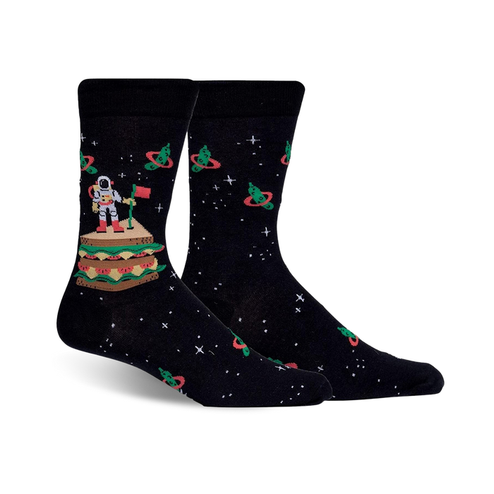 Pair of black crew socks with an astronaut on a sandwich in space, surrounded by orbiting pickles. Red, green, and white details against a dark background. }}