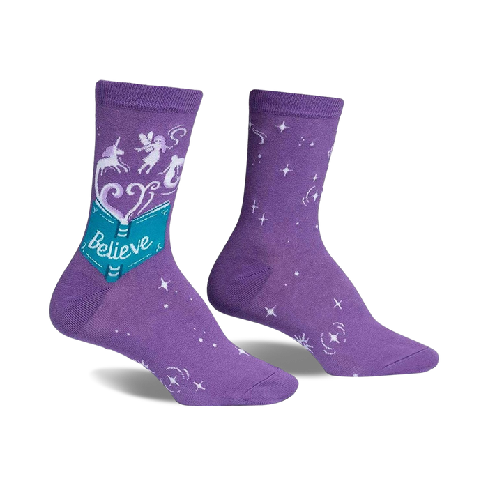 Purple crew socks with a whimsical design. Features a teal book with 'Believe', unicorns, fairies, and white stars. }}