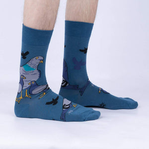 A pair of blue socks with a pattern of cartoon pigeons on them.