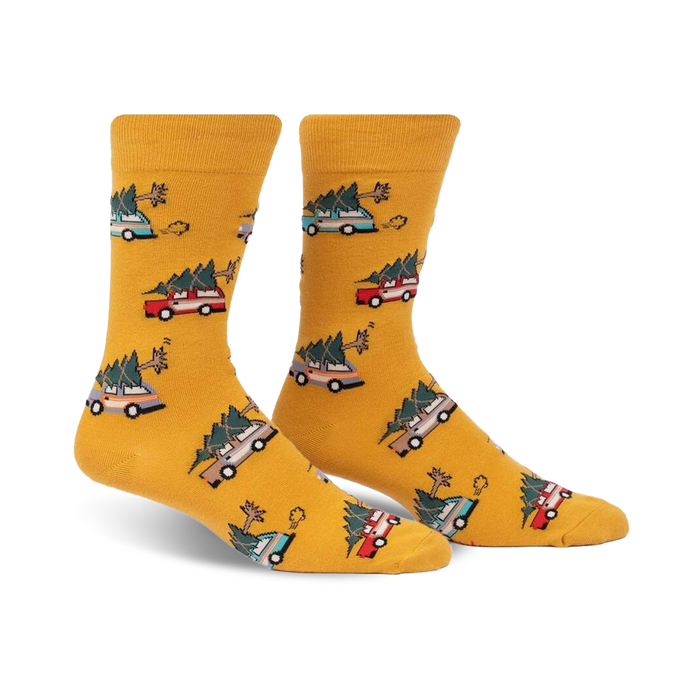 yellow crew socks with festive pattern of green, red, and blue christmas trees and brown cars carrying them. for men.   