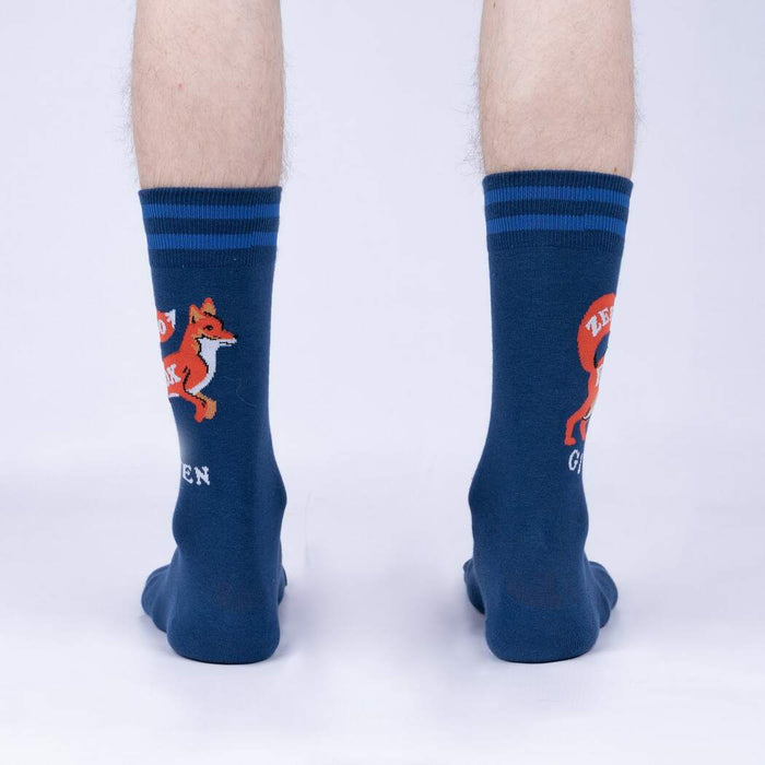 A pair of blue socks with a fox wearing a red shirt and the text 