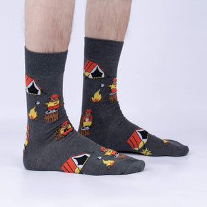 A pair of gray socks with a pattern of cartoon beavers camping on them. The beavers are wearing red hats and holding camping gear.