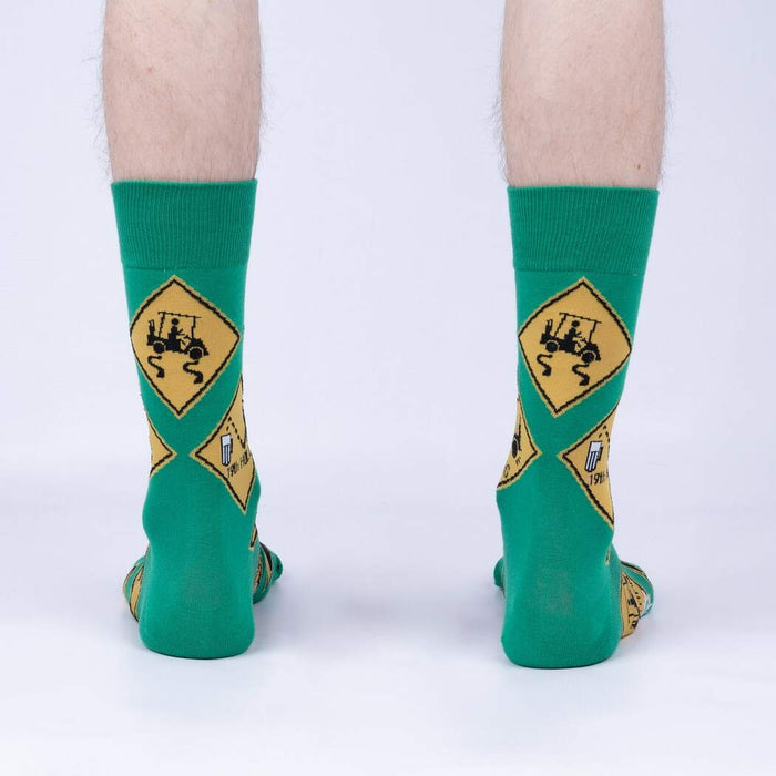 A pair of green socks with a yellow diamond pattern featuring a black golf cart and beer mug graphic.