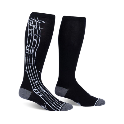Pair of black knee-high socks with a white musical note design on the side. Grey accents at the cuffs.