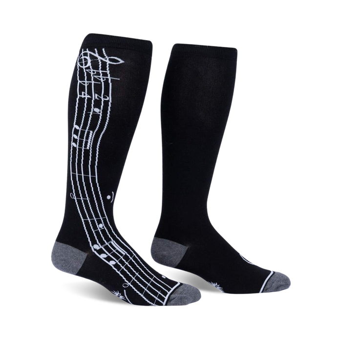 Pair of black knee-high socks with a white musical note design on the side. Grey accents at the cuffs.