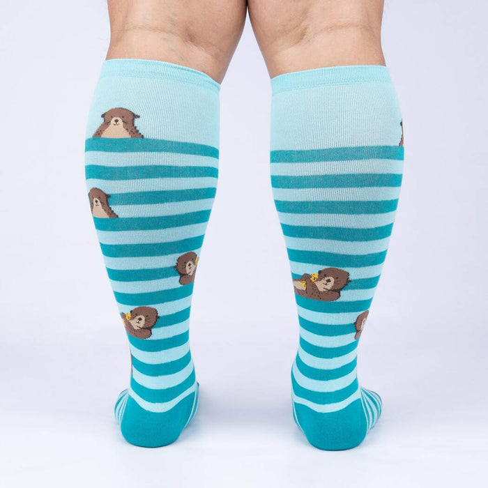 Light blue knee-high socks with a pattern of cartoon otters in brown on them.