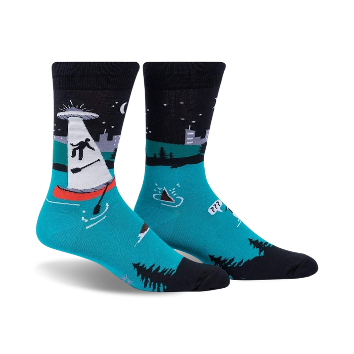 Pair of crew socks; teal, black, and white; features an illustration of a sailboat being abducted by a UFO at night.