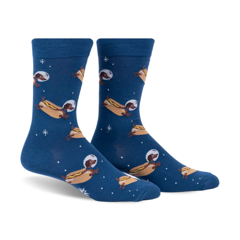 Crew socks in dark blue featuring dachshunds dressed as astronauts on hot dogs floating in space. Fun and quirky design.