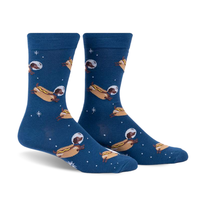 Crew socks in dark blue featuring dachshunds dressed as astronauts on hot dogs floating in space.  Fun and quirky design.