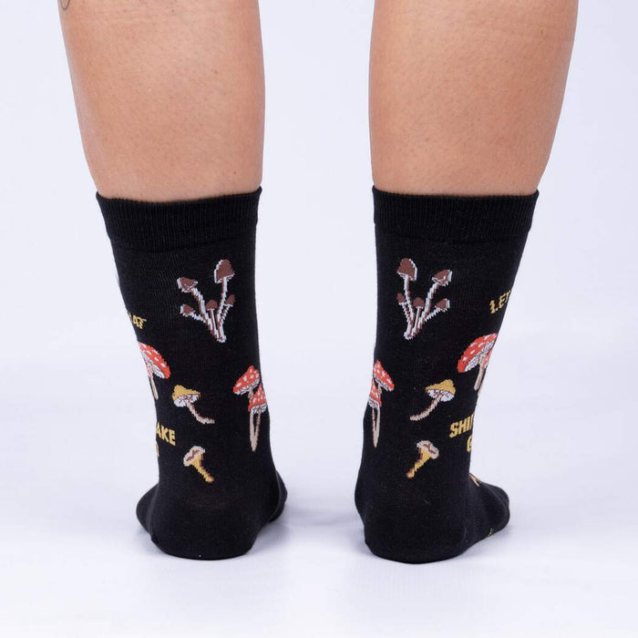 A pair of black socks with a pattern of different types of mushrooms on them. The socks are mid-calf length and the mushrooms are in a variety of colors including red, orange, yellow, and white.