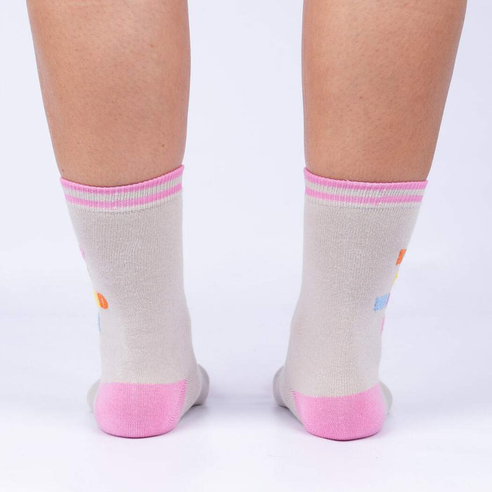 Rear view of 'Keep It Weird!' socks on a person's legs, showing the pink cuffs and subtle sock details.