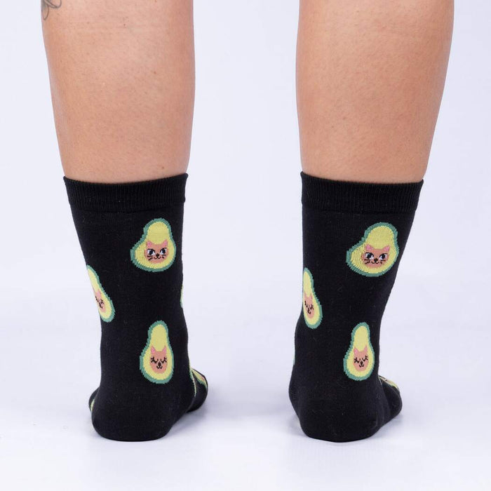 Back view of the same socks shown on a person's legs.  The avocado-cat design is clearly visible from behind.