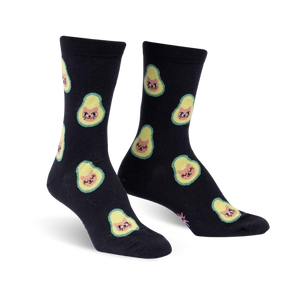 Pair of black crew socks featuring a repeating pattern of avocados with cute cat faces.  The avocados are light green and yellow.