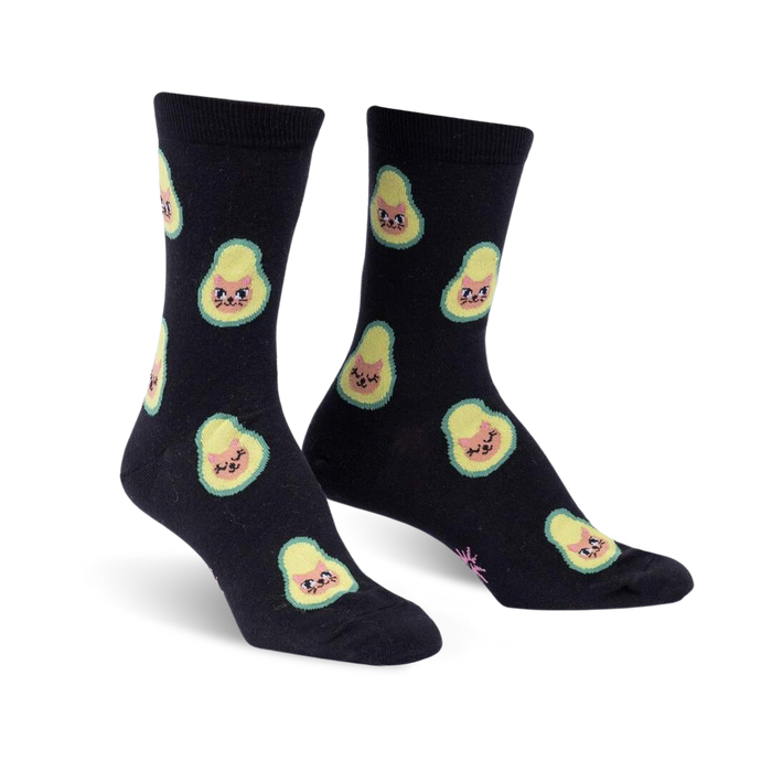 Pair of black crew socks featuring a repeating pattern of avocados with cute cat faces.  The avocados are light green and yellow.