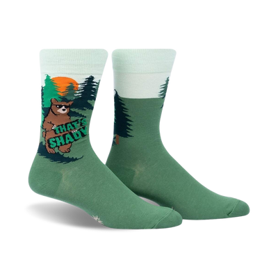 Crew socks in green and mint green featuring a cartoon bear in a forest scene. The bear holds a sign that says 'That's Shady'.