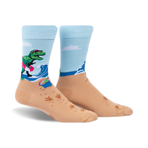 Crew socks in light blue and tan. Design features a T-Rex on a surfboard at the beach with wave and footprint details.