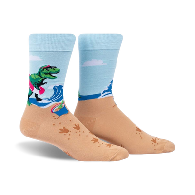 Crew socks in light blue and tan. Design features a T-Rex on a surfboard at the beach with wave and footprint details.