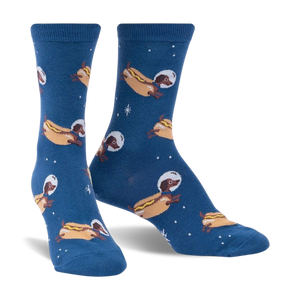 Crew socks in dark blue featuring a repeating pattern of dachshunds dressed as astronauts on hot dogs in space.  Glows in the dark!