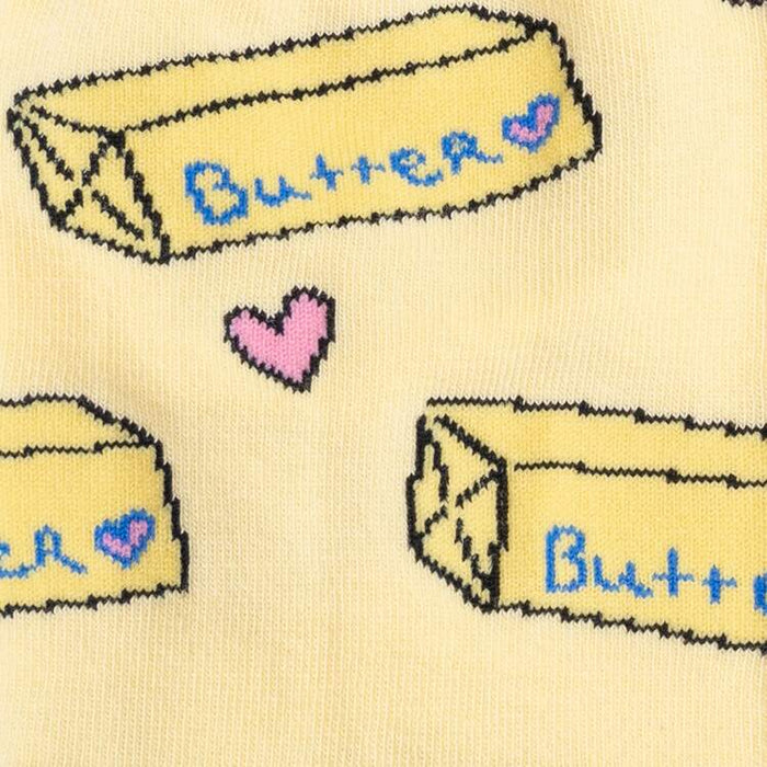 Close-up detail shot of the sock fabric, emphasizing the butter pat and heart design elements.