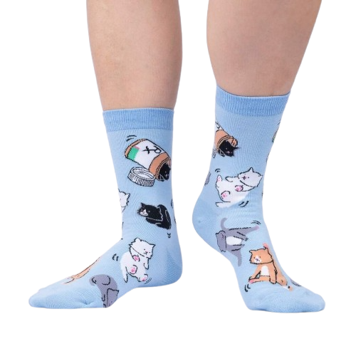 Lifestyle shot of a person wearing the light blue crew socks with cat and pill bottle design.