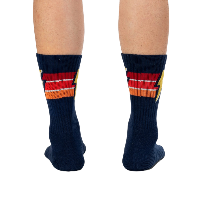 Rear view of navy blue Thunderstruck socks on a person's legs.