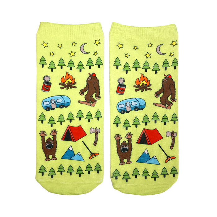A pair of lime green ankle socks with a fun camping design. The pattern includes Bigfoot, a camper, tent, trees, and stars. }}