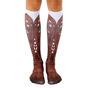 Pair of knee-high socks showcasing a brown cowboy boot design on a white background.  Detailed stitching and wear effects are visible.
