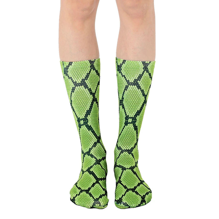 Pair of lime green and black snakeskin-print crew socks shown on a model's legs.