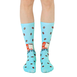 Pair of light blue crew socks with a retro coffee cup design and scattered coffee beans.  'Instant Human' text is visible.
