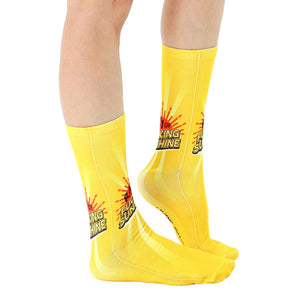 Lifestyle shot showing the socks on a person's legs;  bright yellow socks with sun graphic and phrase.