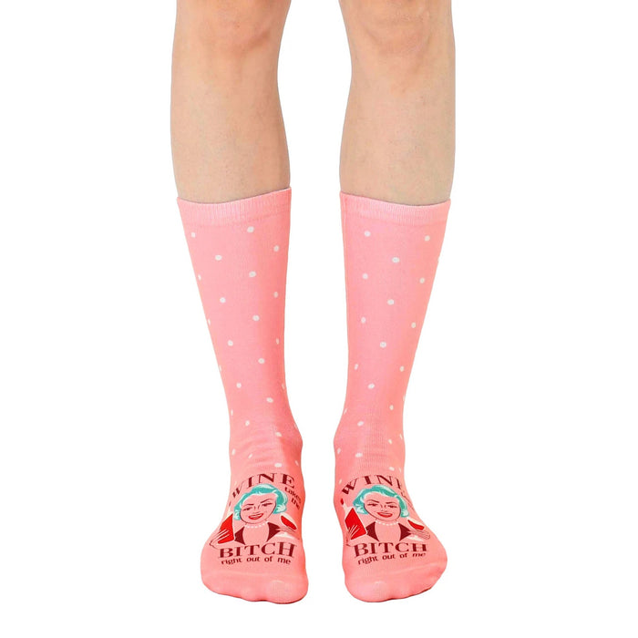 Women's crew socks in pink with white polka dots and a retro illustration of a woman with wine, saying 'Wine Bitch'.