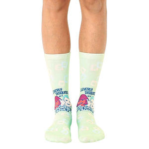 Pair of light green crew socks with a retro design featuring cartoon characters and the text 'Cleverly Disguised as a Responsible Adult'.