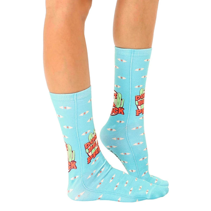 A pair of blue socks with a pattern of cartoon cacti and the words 