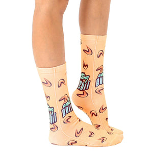 An image of a person's legs wearing a pair of orange socks that have a pattern of boomerangs and the words 
