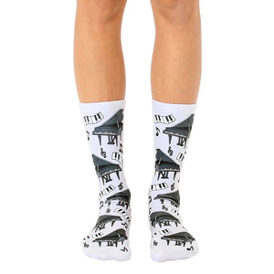 A pair of white crew socks with a fun print of black grand pianos and musical notes.  Perfect for music lovers!