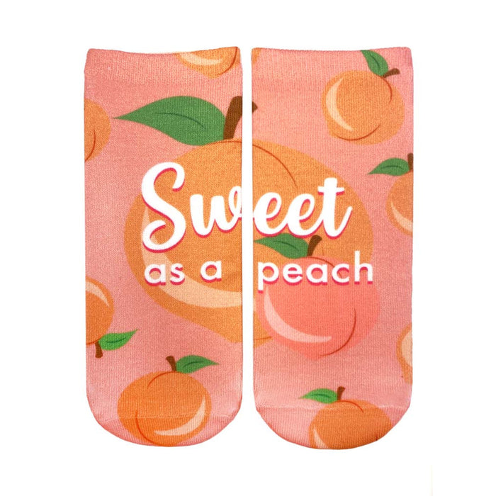 Pair of pink ankle socks with a peach pattern.  The socks say 'Sweet as a peach' in white script. Peaches are illustrated with green leaves. }}